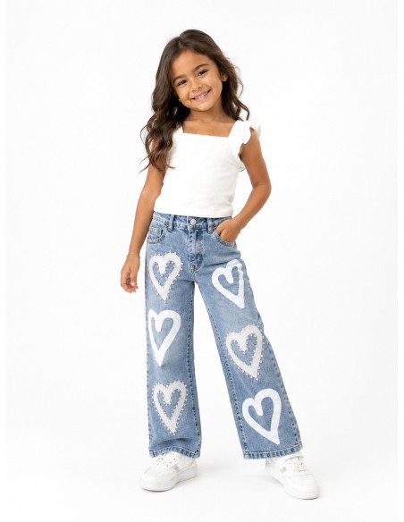 Fillette portant un jean fille cœurs avec un top blanc